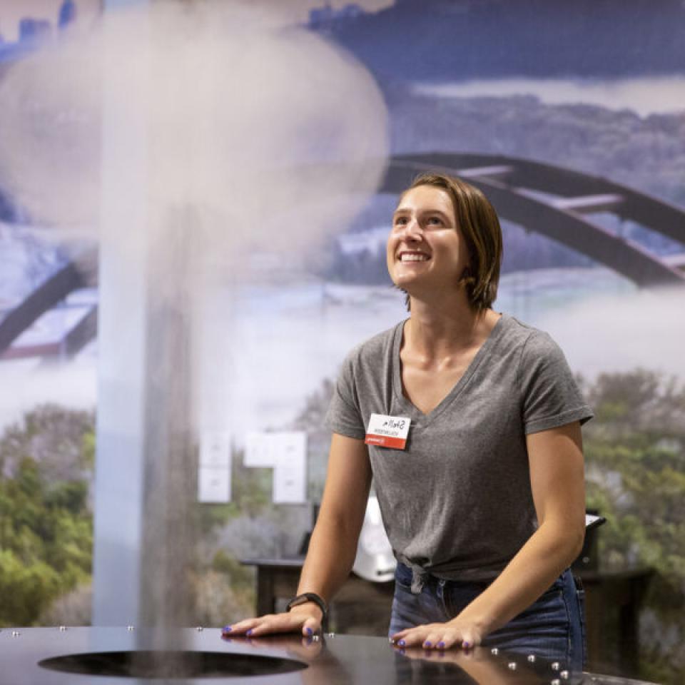 Stella Cunningham interacts with an exhibit while volunteering at The Thinkery.