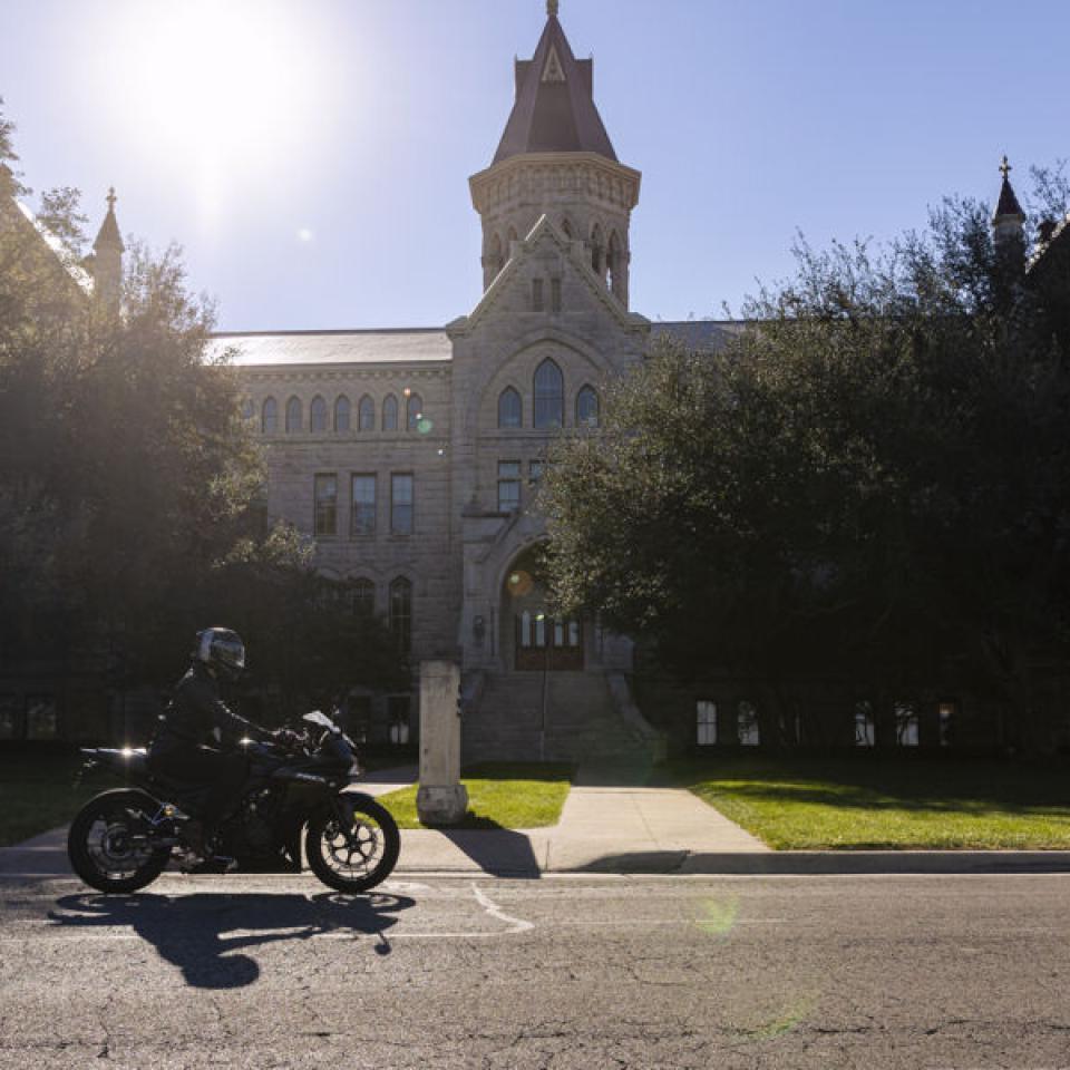 Sabur汗在学校主楼前骑摩托车 