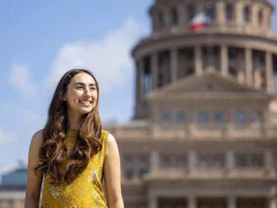 St. Edward's student Michelle Flores stands in front of the Texas Capitol building, where she is interning.