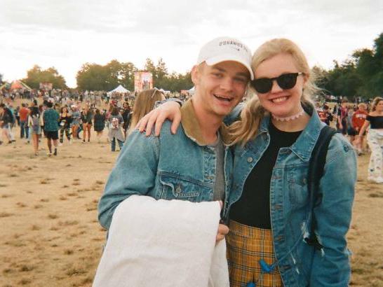 A man and a woman wearing denim jackets posing for the camera