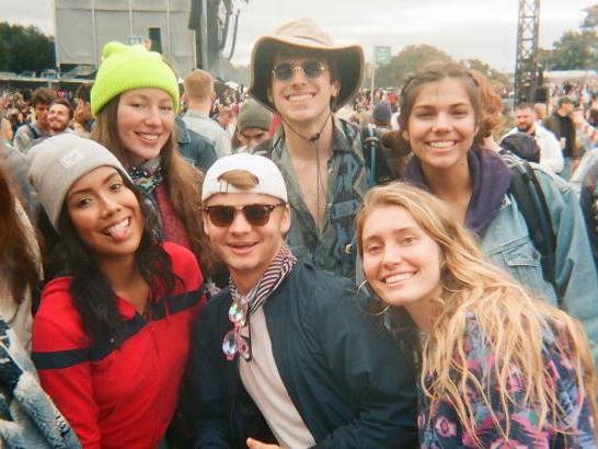 A group of 6 friends posing in front of a large crowd